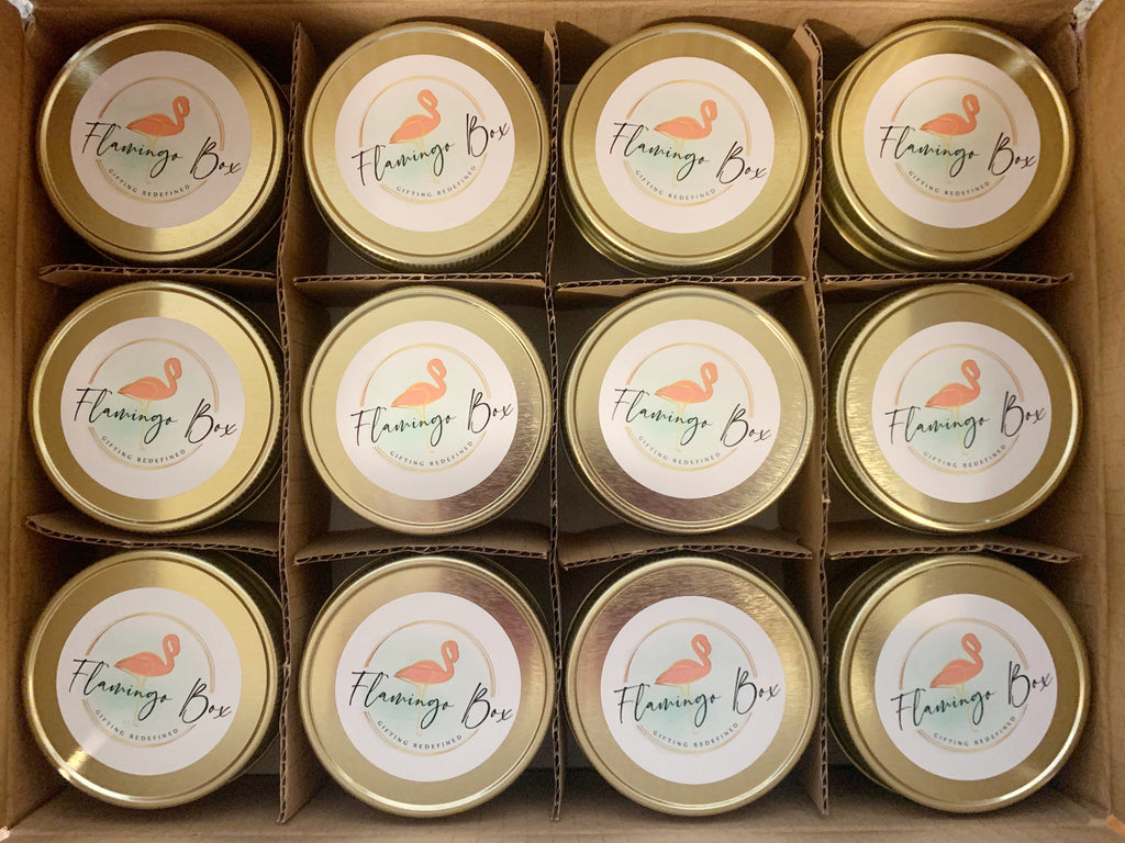 custom branded candles for a gift box company. Gold lids have a flamingo on them for this woman owned gift box company 